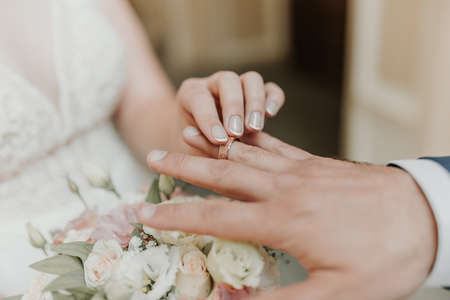 The bride and groom exchange wedding rings. Hands of newlyweds with wedding ringsの写真素材