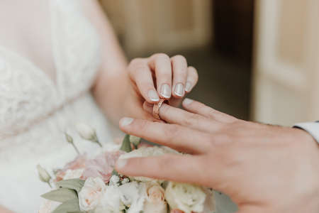 The bride and groom exchange wedding rings. Hands of newlyweds with wedding ringsの写真素材