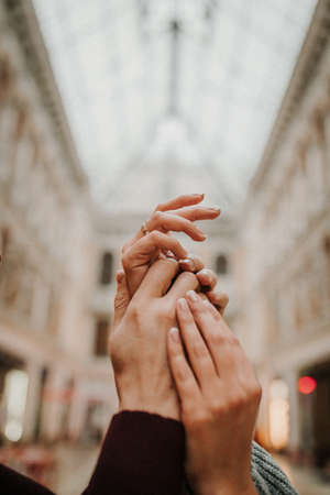 A gentle touch of the hands of a man and a woman close-up. A loving couple holding hands.の写真素材