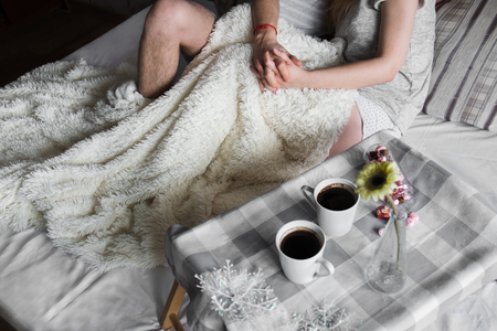 young beautiful couple embracing in bedの写真素材