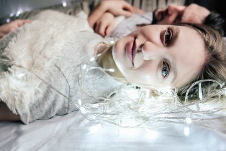 young beautiful couple embracing in bedの写真素材