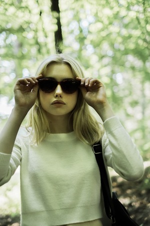 portrait of a beautiful young blonde in the forest among the treesの写真素材