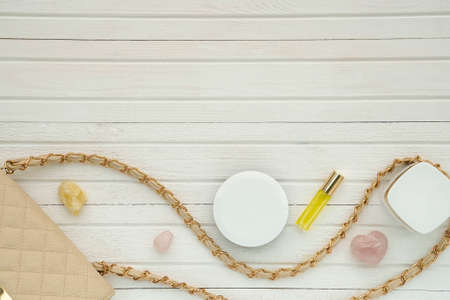 Womens flatlay with handbag, cosmetics, perfume and minerals on white wooden background.の写真素材