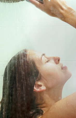 Young woman taking shower. Concept of simple pleasures, relaxing and healthcare
