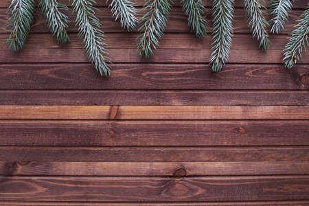 Flat lay with wooden table and silver spruce. Christmas and new year background in brown and green....