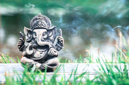 Sculpture of Ganesha god in the background of the river and smoke.の写真素材