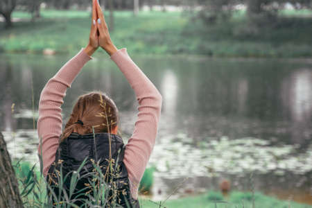 Young woman practicing yoga at the natureの写真素材