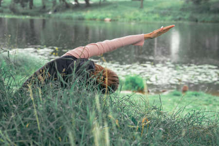 Young woman practicing yoga at the natureの写真素材