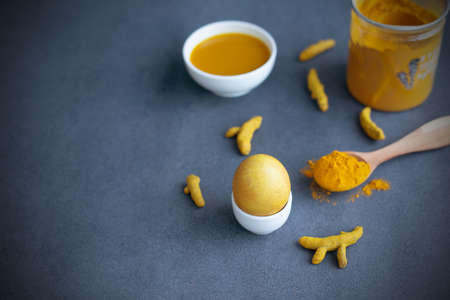 Instructions how to color easter eggs with natural dye. Yellow color from turmeric. Copy space. Gray...