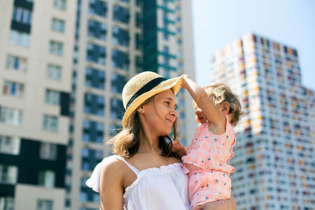 Woman summer clothing having fun urban landscape little kid daughterの写真素材