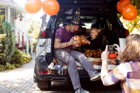 Family celebrating Halloween car trunk. Having fun together. Autumnの写真素材