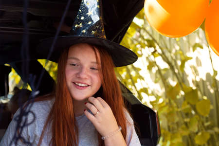 Girl generation Z red hair witch celebrating Halloween car trunkの写真素材