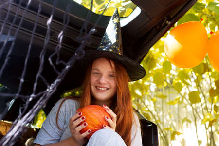 Girl generation Z red hair witch celebrating Halloween car trunkの写真素材