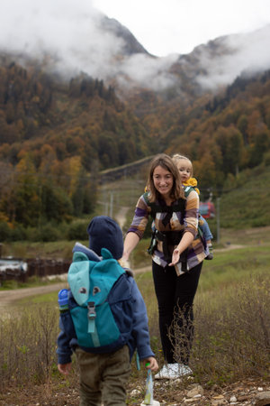 Young woman hiking mountains with two kids. Autumn family adventureの写真素材