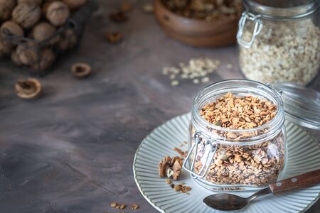 Homemade granola with nuts and seeds in glass jar for healthy breakfast.