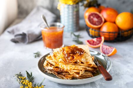 Pancakes with jam or marmalade made from red orange. Tasty breakfast. Crepe suzette pancakes with orange sauceの写真素材