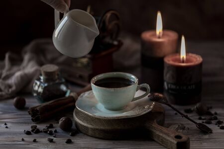 Cup of coffee Crema with chocolate chip cookies, marshmallows and burning candlesの写真素材
