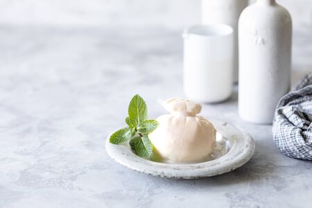 Italian burrata cheese on a round white plate on a light background. Copy space.の写真素材