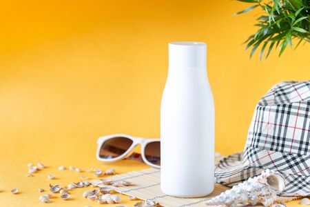Suncream bottles, glasses, starfish palm leaves on a yellow background. Beauty and care in the summer.の写真素材