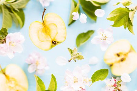 Apples, flowers and leaves of an apple tree in flight. Fresh spring texture leaves of different...