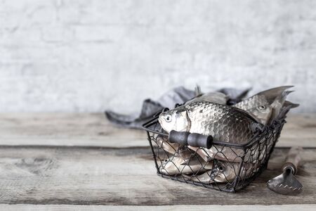 Raw fresh river fish in a bowl on a wooden table. Copy spaceの写真素材