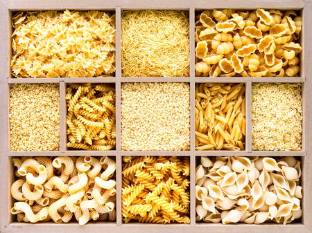 Different types of italian uncooked pasta in wooden box, whole wheat pasta, pasta, spaghetti, noodles, tagliatelle. Top view.の写真素材