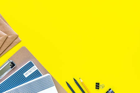 Assorted colorful stationery for school and office on yellow background with copyspace.の写真素材