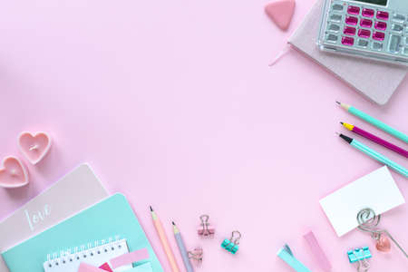 Various colorful stationery for school and office on pink background with copyspace