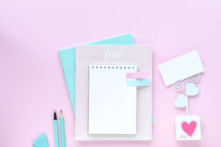 Various colorful stationery for school and office on pink background with copyspace
