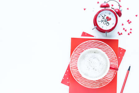 Red coffee cup and gift box on white table. Top view with copy space.