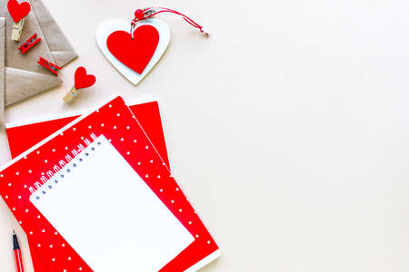 Notebooks and envelopes for school or office in red on a white table with copy space