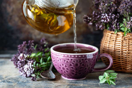 Healthy tea from oregano flowers in a beautiful mug on a wooden backgroundの写真素材