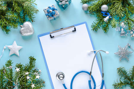 Stethoscope, thermometer, blank clipboard and Christmas decorations. Medical concept. New Year's and Christmas. Greeting card. Top viewの写真素材