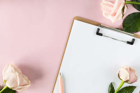 Clipboard mockup on light pink background with pink roses.