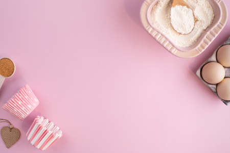 Frame of food ingredients for baking on gently pink pastel background. Cooking flat lay with copy space. Tの写真素材