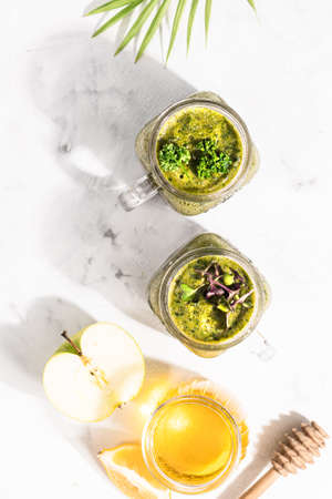 Green detox cocktails in two cans, standing on a white table, top view, healthy lifestyle concept.の写真素材