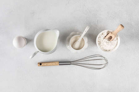 Background for baking cakes and donuts. Baking ingredients - flour, egg, milk, sugar on a white background.の写真素材