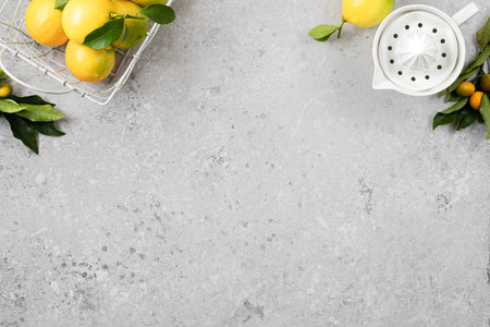 Fresh lemons with leaves in a metal basket on a white stone background, Top view. copyspace.の写真素材