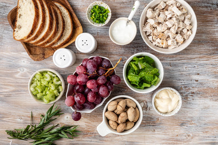 Ingredients for salad with chicken breast, tarragon, pecans and grapes. Wooden backgroundの写真素材