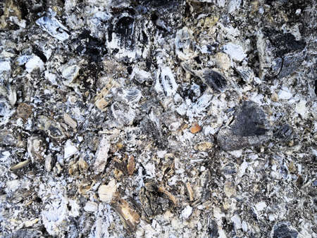 Ash texture, blurred background. Smoldering coal. wood ash in the fireplace. Defocused charcoal with...