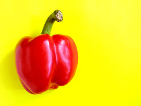 Red bell pepper close-up, sweet red pepper on a yellow background, food preparation, bright yellow backgroundの写真素材