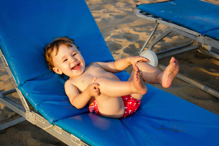The kid laughs lying on a deckchairの写真素材