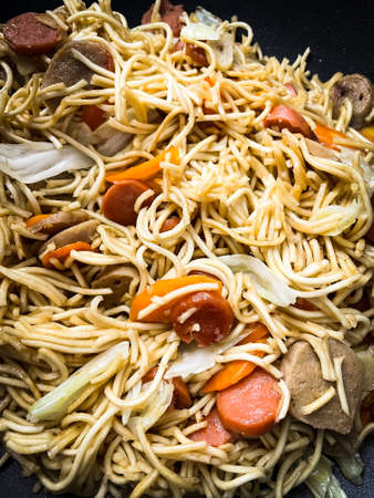 Homemade asian fry noodle with sausage, vegetables, and meatballsの写真素材