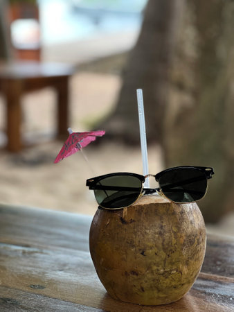 Drinking coconut drink with sunglasses and umbrella.の写真素材