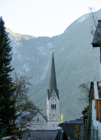 Salzkammergut, Austria â October 3, 2025: Close-up of Hallstatt Church Steeple with Alpine Mountain Background.の写真素材