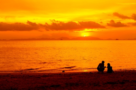 couple silhouette on a beach on sunset backgroundの写真素材