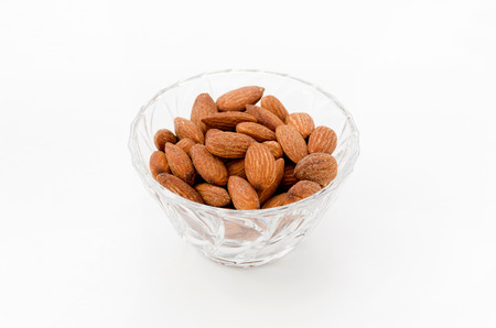 group of almonds in Glass container isolated white backgroundの写真素材