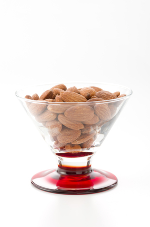 group of almonds in Glass container isolated white backgroundの写真素材