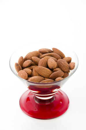 group of almonds in Glass container isolated white backgroundの写真素材