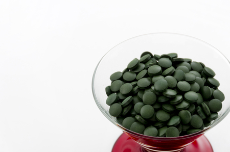Green pills, Spirulina tablets in glassの写真素材